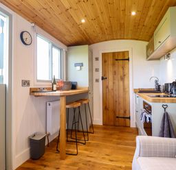 A kitchen with a bar table and stools at Charollais in Oswestry