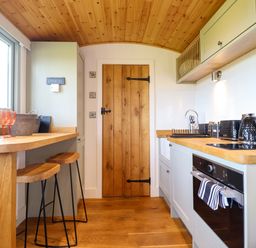A kitchen with a countertop and stools at Charollais Oswestry