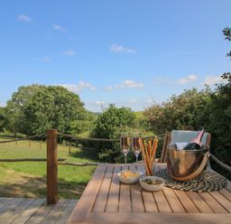An outdoor area with a table set for drinks and snacks at Squirrel's Drey in Chapel Lawn near Clun