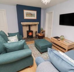 A living room with a sofa and television at Linn Cottage in Hexham