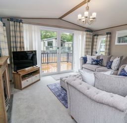 A living room with a sofa and television at The Beaumont No 34 in New Quay