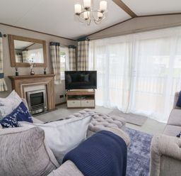 A living room with a sofa and television at The Beaumont No 34 in New Quay