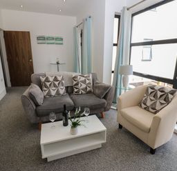 A living room with a sofa and armchair at Harbour View in Whitehaven