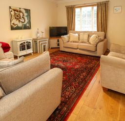 A living room with sofas and a coffee table at Fairways House in Weymouth