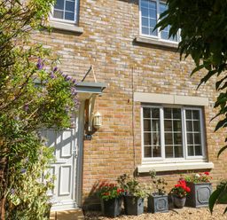An outdoor view of a house with a door and flower pots at Fairways House in Weymouth