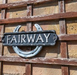 A decorative sign on a trellis wall at Fairways House in Weymouth
