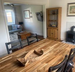 A dining room with a wooden table and chairs at Bari House in Seahouses