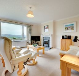 A living room with furniture and large windows at The Granary in Alnwick