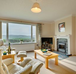 A living room with an armchair, coffee table, and fireplace at The Granary in Alnwick