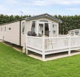 A mobile home with a deck and lawn at Kelly's Retreat Scarborough