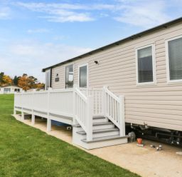 A mobile home with a deck and grass area at Kelly's Retreat in Scarborough