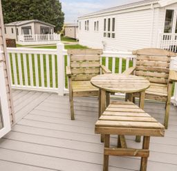 A deck with wooden chairs and a table at Kelly's Retreat in Scarborough