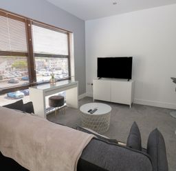 A living room with a sofa and television at Harbourside Apartments in Whitehaven