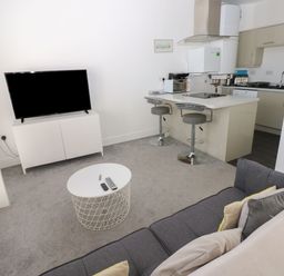 A living room with a television and kitchen island at Harbourside Apartments Whitehaven