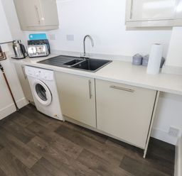 A kitchen with a sink and washing machine at Harbourside Apartments in Whitehaven