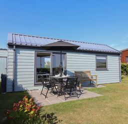 A cabin with a dining table and chairs outside at Stella Maris in Torpoint