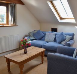 A snug with a sofa and coffee table at The Stables Budock Water near Falmouth