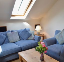 A living room with a sofa and armchair at The Stables Budock Water near Falmouth