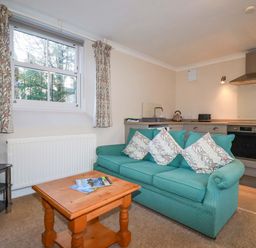 A living room with a sofa and television at Horseshoe Cottage in Falmouth