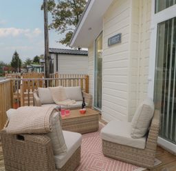 An outdoor seating area with a sofa and coffee table at Labernum in Lytham St. Annes