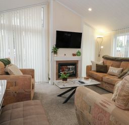 A living room with a television and two sofas at Labernum in Lytham St. Annes