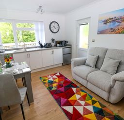 A kitchen with a sofa and dining area at Pinecroft Annex Stepaside near Saundersfoot