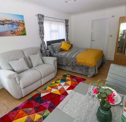 A living room with a bed and sofa at Pinecroft Annex Stepaside near Saundersfoot