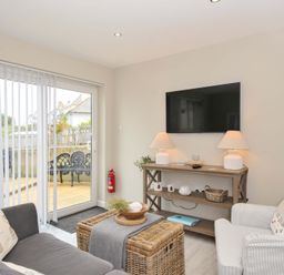 A living room with a television and seating at Evelyn in Looe
