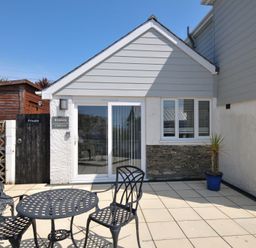 An outdoor seating area with chairs and table at Evelyn in Looe