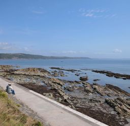A person sitting by the shoreline at Evelyn in Looe