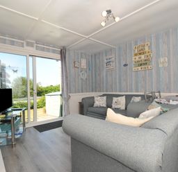 A living room with a sofa and television at 13 Hillside, Bude