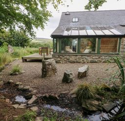 A garden with a deck and rocks at The Dovecote Llanychaer near Fishguard
