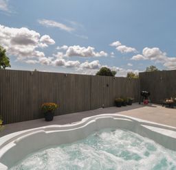 An outdoor area with a hot tub and patio furniture at Noflash Malpal in Bishop Sutton