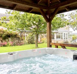 A hot tub in a garden at Bush Nook House in Brampton, Cumbria