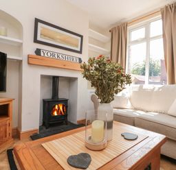 A living room with a sofa and television at Moot Cottage in Driffield