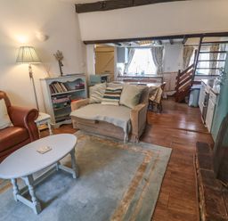 A living room with a sofa and coffee table at Buttercup in Blakeney, Norfolk