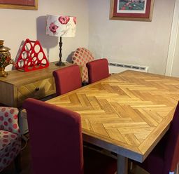 A dining room with a wooden table and red chairs at The Bittern in Blakeney, Norfolk