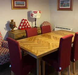 A dining room with a wooden table and red chairs at The Bittern in Blakeney, Norfolk
