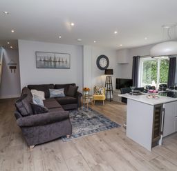 A living room with a sofa and kitchen island at Beach Hideaway