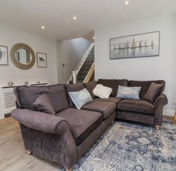 A living room with a sofa and carpet at Beach Hideaway