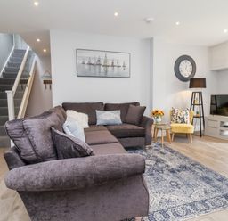 A living room with a sofa and television at Beach Hideaway