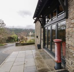 An outdoor view with a building entrance and a post box at The Barn at Sunny Barn Brecon