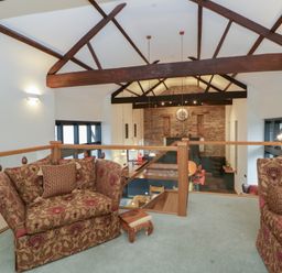 A living room with armchairs and a dining area at The Barn at Sunny Barn in Brecon