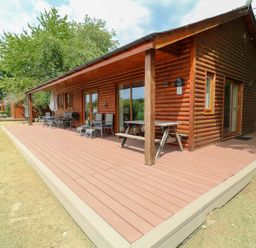 A log cabin with a deck and outdoor seating at Sunnyside Lodge in Thorpe-On-The-Hill