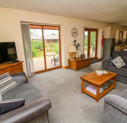A living room with sofas and a television at Sunnyside Lodge in Thorpe-On-The-Hill