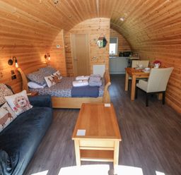 A living area with bed and dining table at Lodge 3 near Pontyates