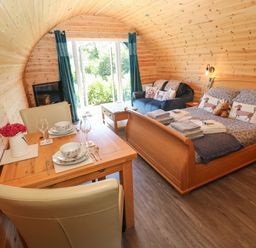 A cabin with a dining area and bed at Lodge 3 near Pontyates