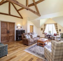 A living room with a sofa and armchairs at Upper Pandy Farm in Berriew near Welshpool