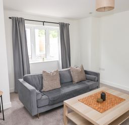 A living room with a sofa and coffee table at Ty Landsker in Houghton near Neyland