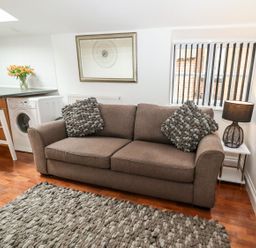 A living room with a sofa and washing machine at Bobby's in Whitby